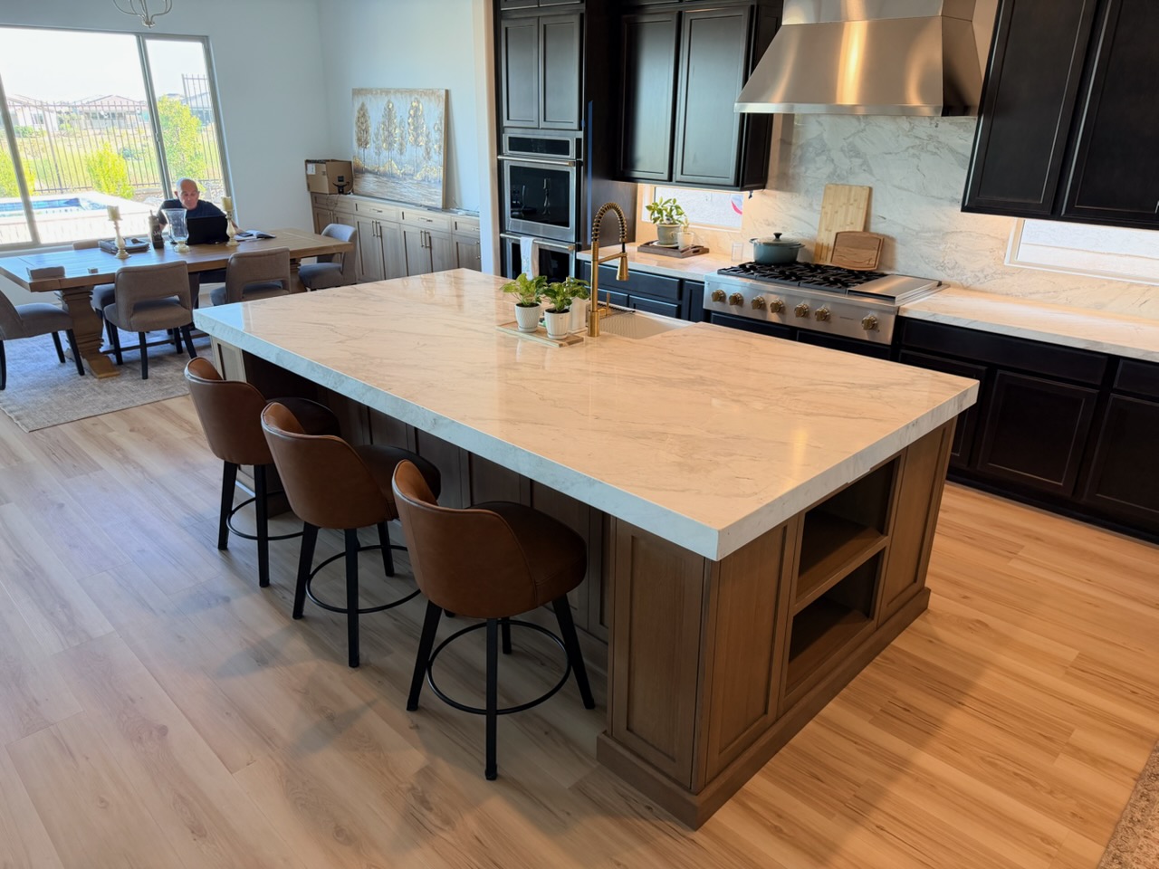 Kitchen island with white marble countertop and leather counter stools