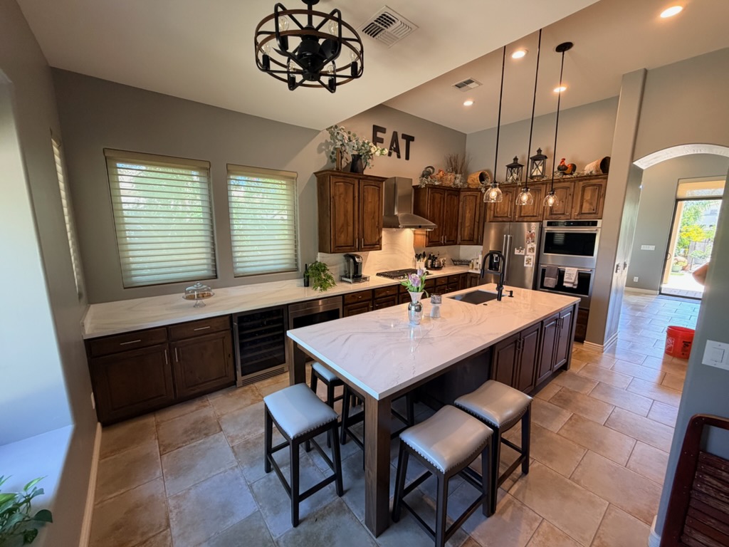 Remodeled kitchen with dark wood cabinets and a large white island